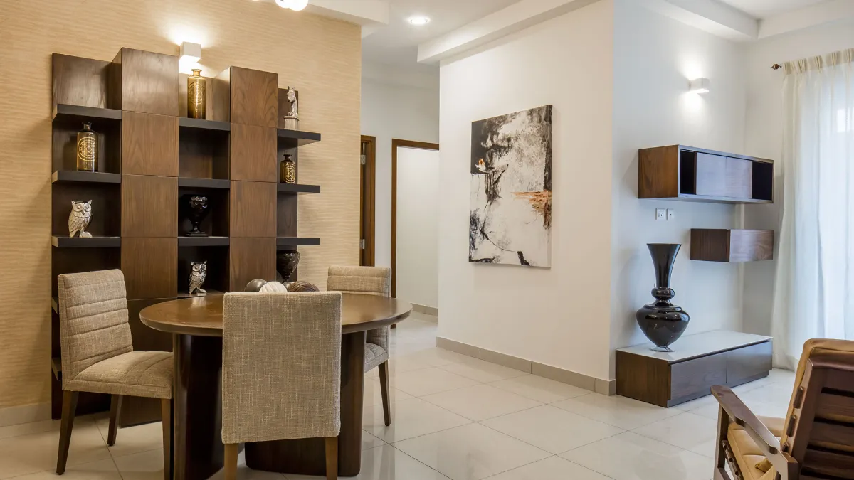 Living and dining interior with round table and wooden display shelving