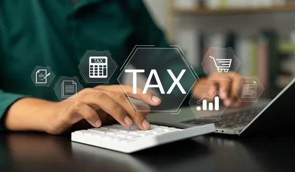 Person calculating GST, stamp duty and property taxes on a laptop